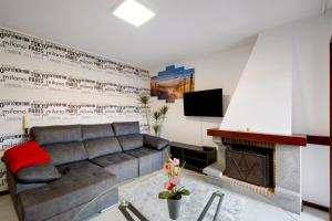 a living room with a couch and a fireplace at Barrinha Beach in Esmoriz
