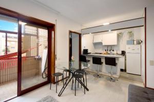 a kitchen and dining room with a glass table and chairs at Barrinha Beach in Esmoriz