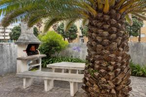 a palm tree next to a picnic table and a pineapple at Barrinha Beach in Esmoriz