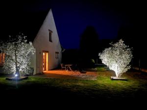 a church at night with two trees with lights at Maison proche dinan au calme in Aucaleuc