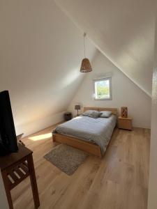 a bedroom with a bed and a tv and a window at Maison proche dinan au calme in Aucaleuc
