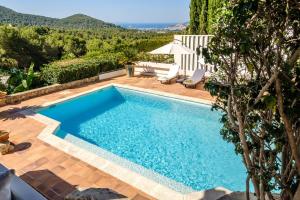 a swimming pool in a backyard with a villa at Can Bernat in Can Furnet