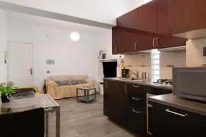a kitchen and a living room with a couch at Piso Leon y Castillo in Arrecife