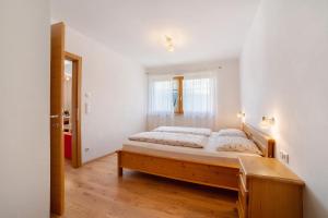 a bedroom with a large bed in a room at Fröhlichhof Wohnung Pergola in Lagundo