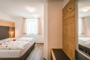 a bedroom with two beds and a closet at Chalet La Flüta Margherita in La Valle