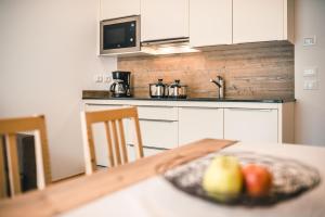 a kitchen with a table with a bowl of fruit on it at Chalet La Flüta Margherita in La Valle +17 photos