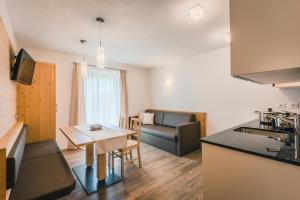 a kitchen and a living room with a table at Chalet La Flüta Margherita in La Valle