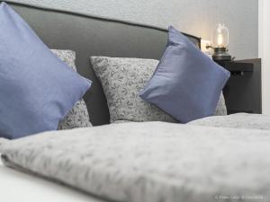 a bed with blue pillows on top of it at Fewo Lago di Costanza I in Friedrichshafen