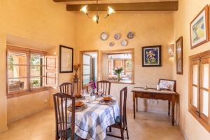 a dining room with a table and chairs and plates on the wall at Son Pou in Sencelles