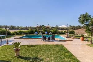 a swimming pool in a yard with chairs and a sidx sidx sidx at Son Pou in Sencelles