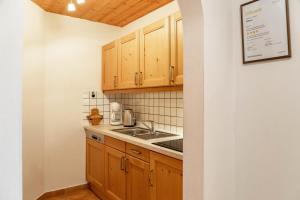 a kitchen with wooden cabinets and a sink at Alpenblick Tilly - Fewo Eibsee 1 in Krün