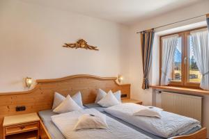 a bedroom with two beds and a window at Alpenblick Tilly - Fewo Eibsee 1 in Krün