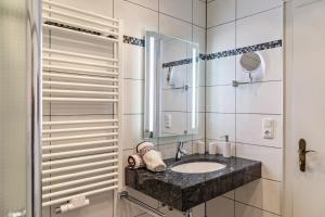 a bathroom with a sink and a mirror at Alpenblick Tilly - Fewo Eibsee 1 in Krün +10 photos