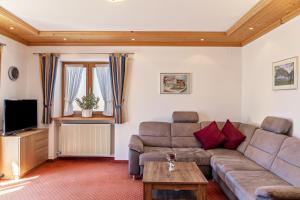 a living room with a couch and a tv at Alpenblick Tilly - Fewo Eibsee 1 in Krün