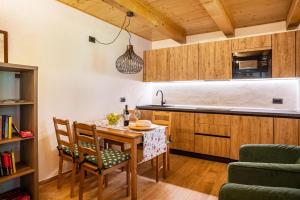 a kitchen with a wooden table and chairs and a counter at Maso Rapunzel in Peio