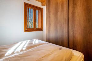 a bed in a room with a window at Maso Rapunzel in Peio