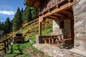 a stone building with a table and a wood stove at Maso Rapunzel in Peio
