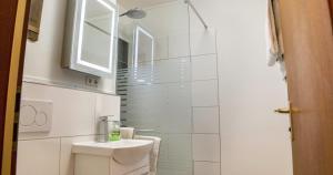 a white bathroom with a toilet and a sink at Ferienwohnung 109 Schwarzwald in Schönwald +9 photos
