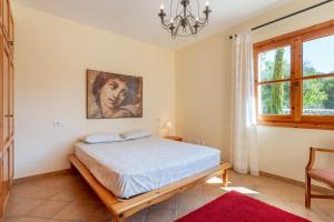 a bedroom with a bed and a painting on the wall at Son Forte Nou in Artá +20 photos