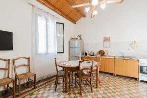 a kitchen with a table and chairs and a refrigerator at Da Giovanni A Custonaci in Custonaci +13 photos