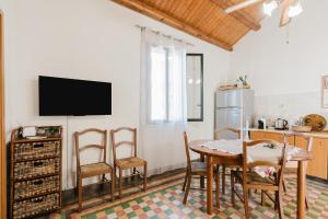 a kitchen with a table and chairs and a television at Da Giovanni A Custonaci in Custonaci
