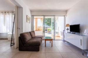 a living room with a chair and a television at Villa de la brune in Bormes-les-Mimosas