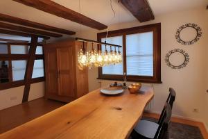 a dining room with a wooden table and a chandelier at Schatzkästchen am Bodensee in Öhningen +17 photos