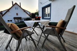 a table and two chairs on a wooden deck at Schatzkästchen am Bodensee in Öhningen
