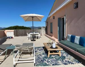 a patio with a table and chairs and an umbrella at Appartement D'exception in Saint-Tropez