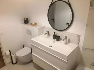 a white bathroom with a sink and a mirror at Appartement D'exception in Saint-Tropez +15 photos