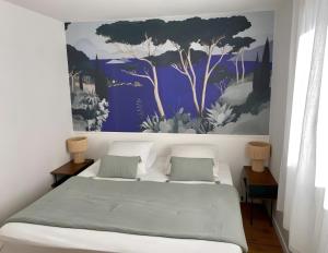 a bedroom with a bed with a painting on the wall at Appartement D'exception in Saint-Tropez