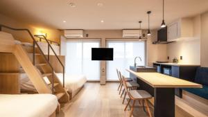 a bedroom with a bunk bed and a kitchen with a desk at ALPHABED INN Hakata station front in Fukuoka