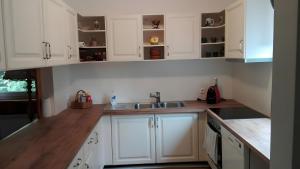 a kitchen with white cabinets and a sink at Ferienhaus Roman in Hinterstoder