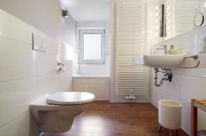 a white bathroom with a toilet and a sink at De Lüttje Utkiek in Bühren +37 photos