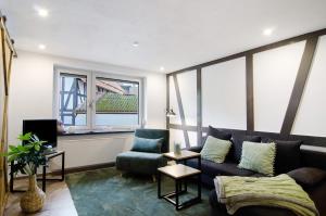a living room with a couch and a chair at De Lüttje Utkiek in Bühren