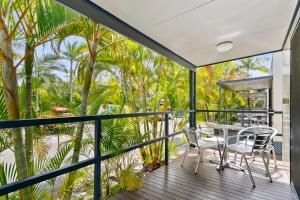 a balcony with a table and chairs and palm trees at Ingenia Holidays Noosa North in Tewantin