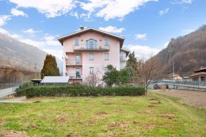 a large pink building in the middle of a field at Casa Sergio in Grosio