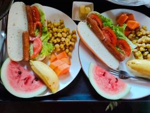 a plate of food with two hot dogs and vegetables at Saha surf camp lesson booking only in Pottuvil