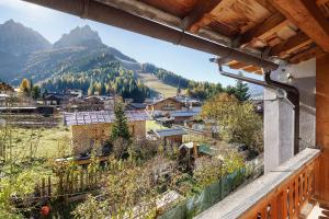 a balcony with a view of a village and mountains at Ciasa Lino Rotic in Gardeccia - San Giovanni di Fassa