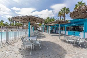 a beach bar with tables and chairs and umbrellas at Coco Canaria in Corralejo