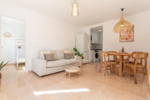 a living room with a white couch and a table at Coco Canaria in Corralejo