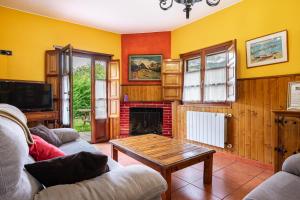 ein Wohnzimmer mit Sofa und Kamin in der Unterkunft Socastillo A in Fresnedo