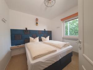 a bedroom with a large bed with a blue headboard at Windjammer in Koserow