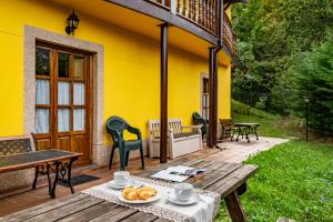 eine Terrasse mit Tisch und Stühlen und einem gelben Haus in der Unterkunft Socastillo A in Fresnedo