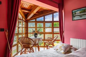 ein Schlafzimmer mit Tisch und Stühlen und einem großen Fenster in der Unterkunft Socastillo A in Fresnedo