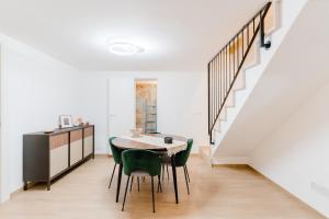 a dining room with a table and chairs and a staircase at Casa Ninì in Galatone