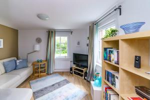 a living room with a couch and a tv at Rosen Hus in Pellworm +11 photos