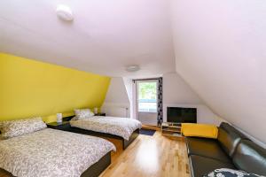 a room with two beds and a couch and a tv at Rosen Hus in Pellworm