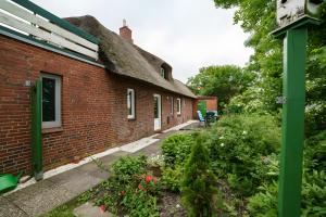 an outside view of a brick building with a garden at Rosen Hus in Pellworm