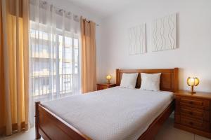 a bedroom with a bed and a large window at Casa De Pardal in Quarteira